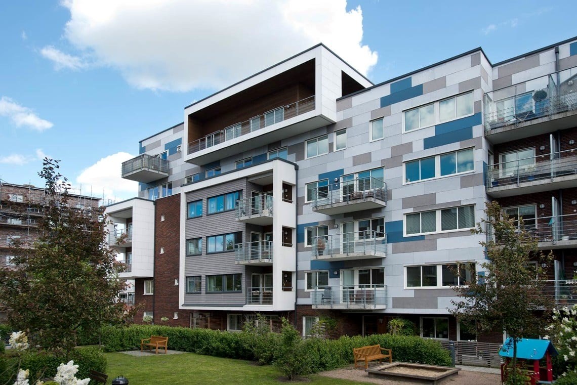 En modern bostadsbyggnad med flera våningar och balkonger. Byggnaden har en samtida design med en b