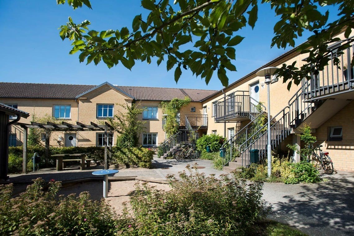 Ett flerfamiljshus i två plan med en grönskande innergård