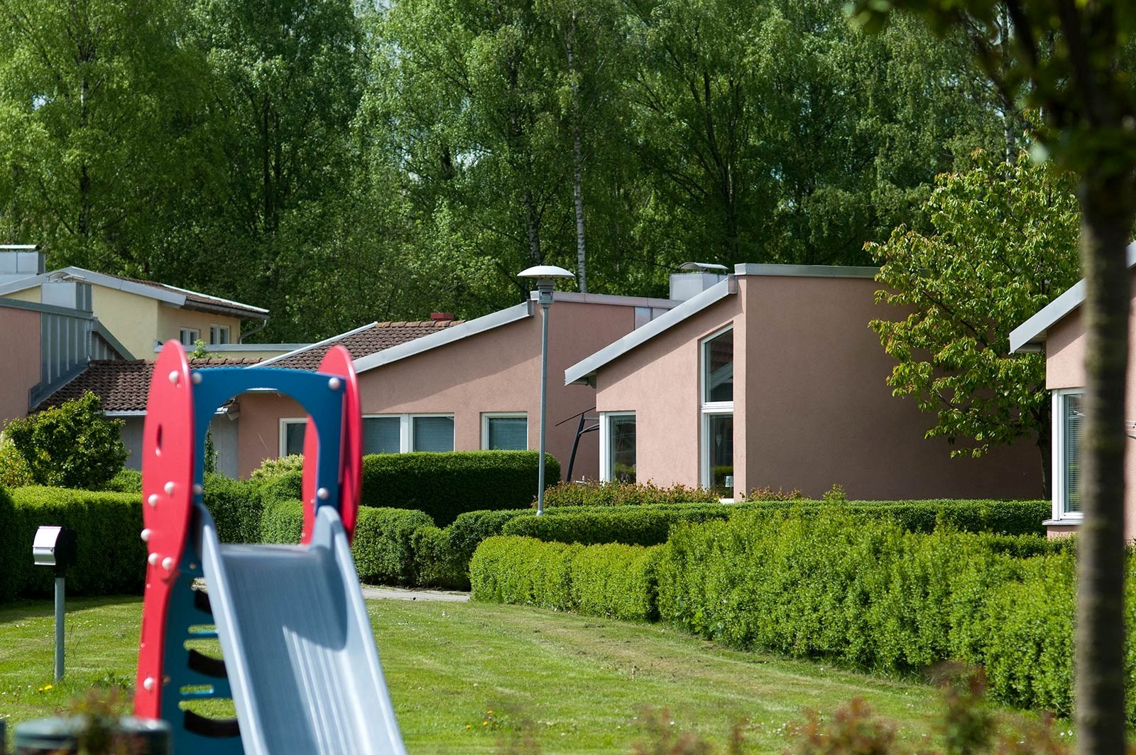 Fastigheter i solen med en lekplats framför