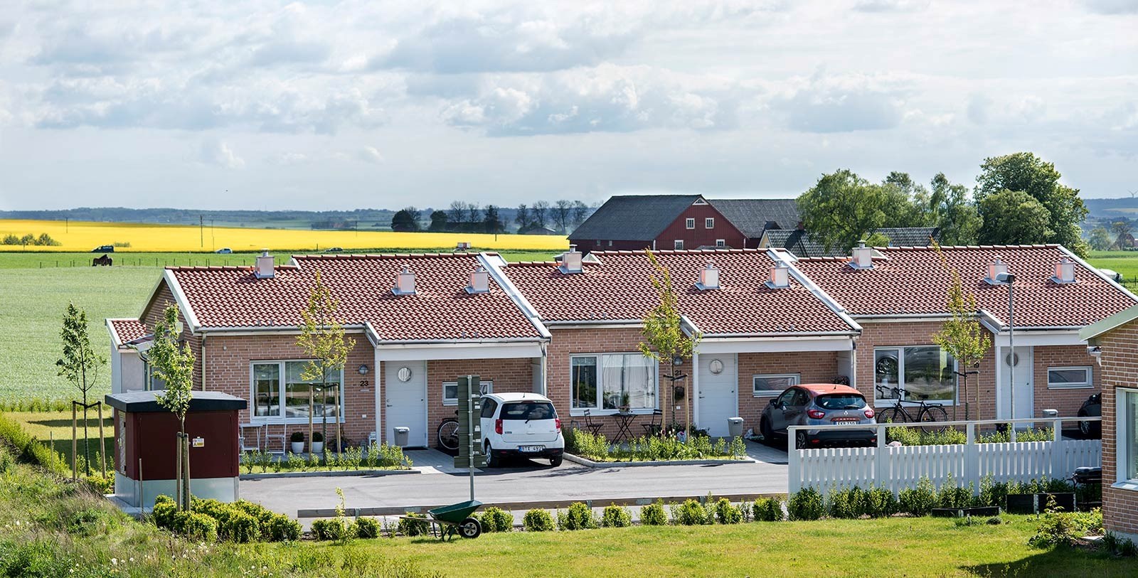 Radhus i solen med rapsfält i bakgrunden