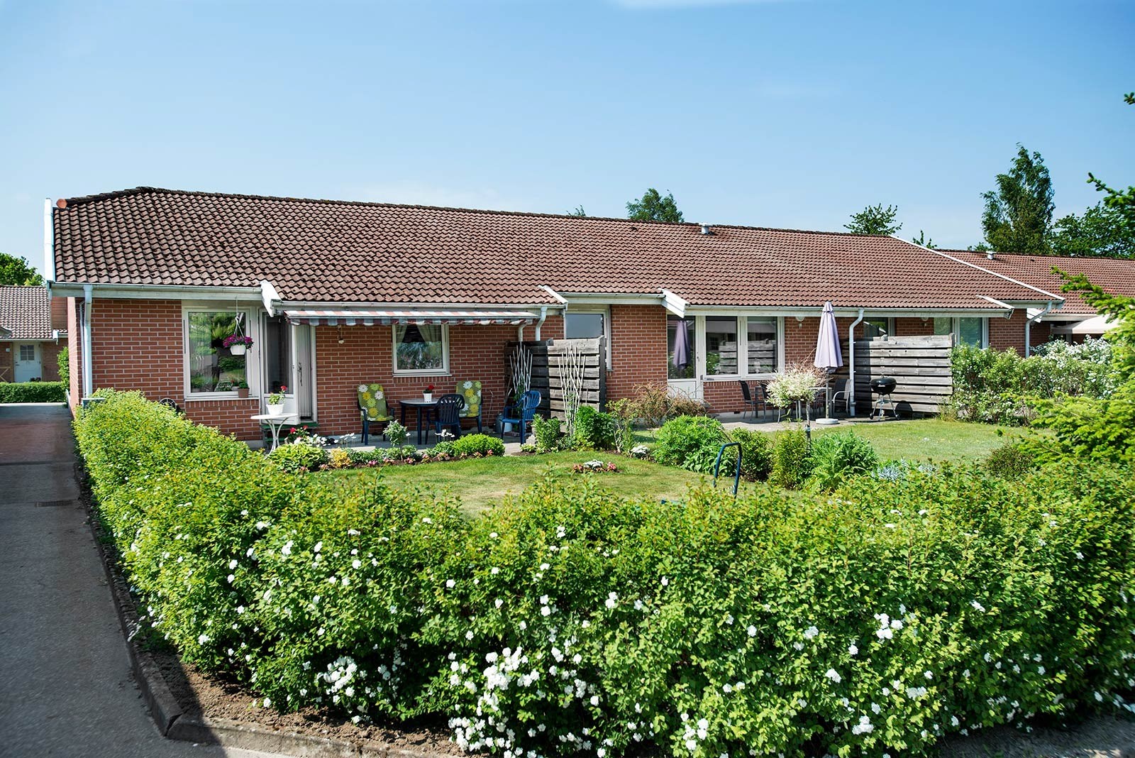 Ett radhus med grönskande trädgård utanför