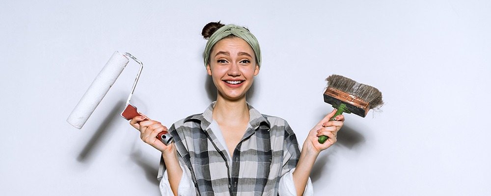 Person som håller i en målarpensel och borste