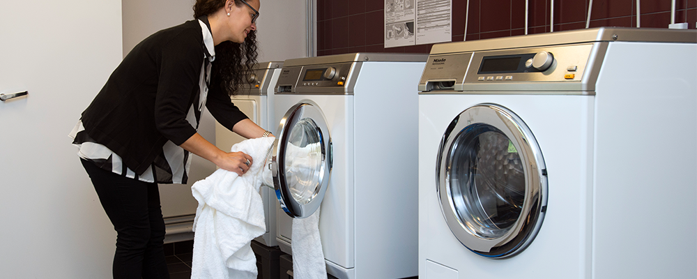 Hyresgäst som tvättar i en gemensam tvättstuga