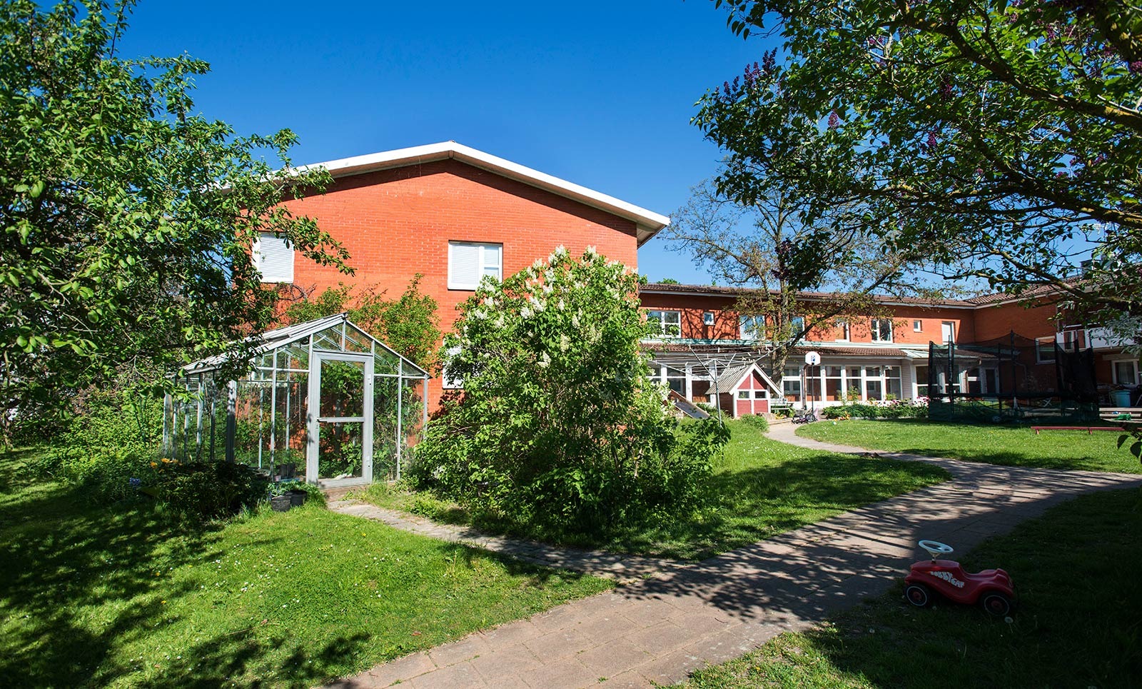 Ett kollektivhus med grönska framför