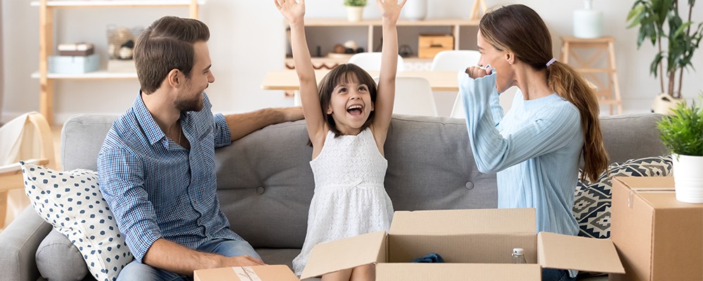 glada föräldrar och flicka som höjer armarna