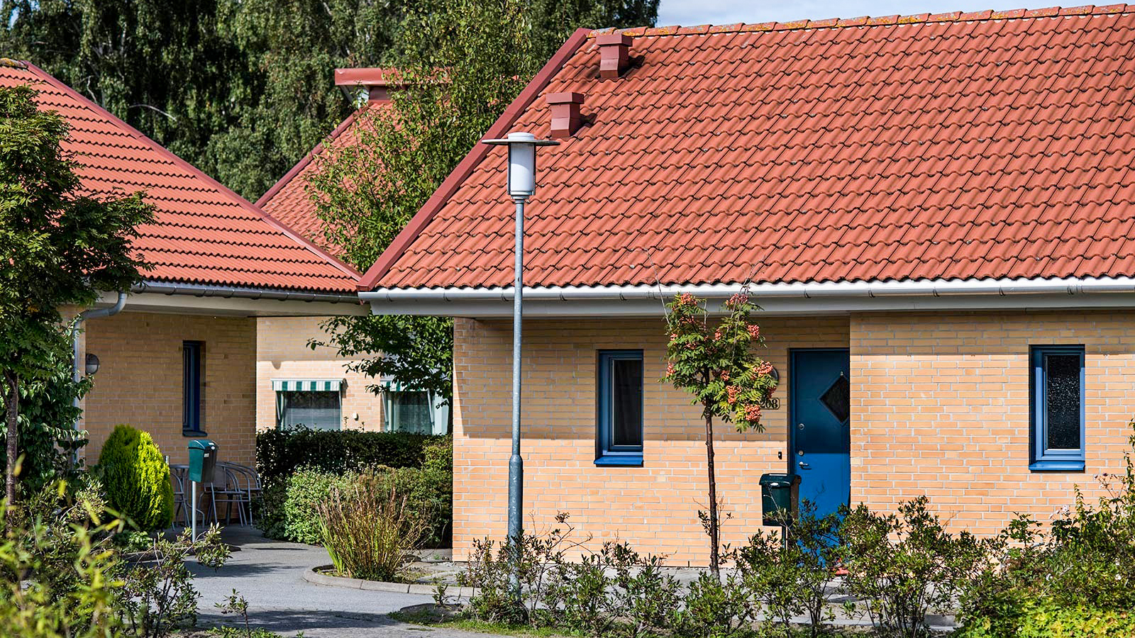 Ett flerfamiljshus med gröna ytor framför