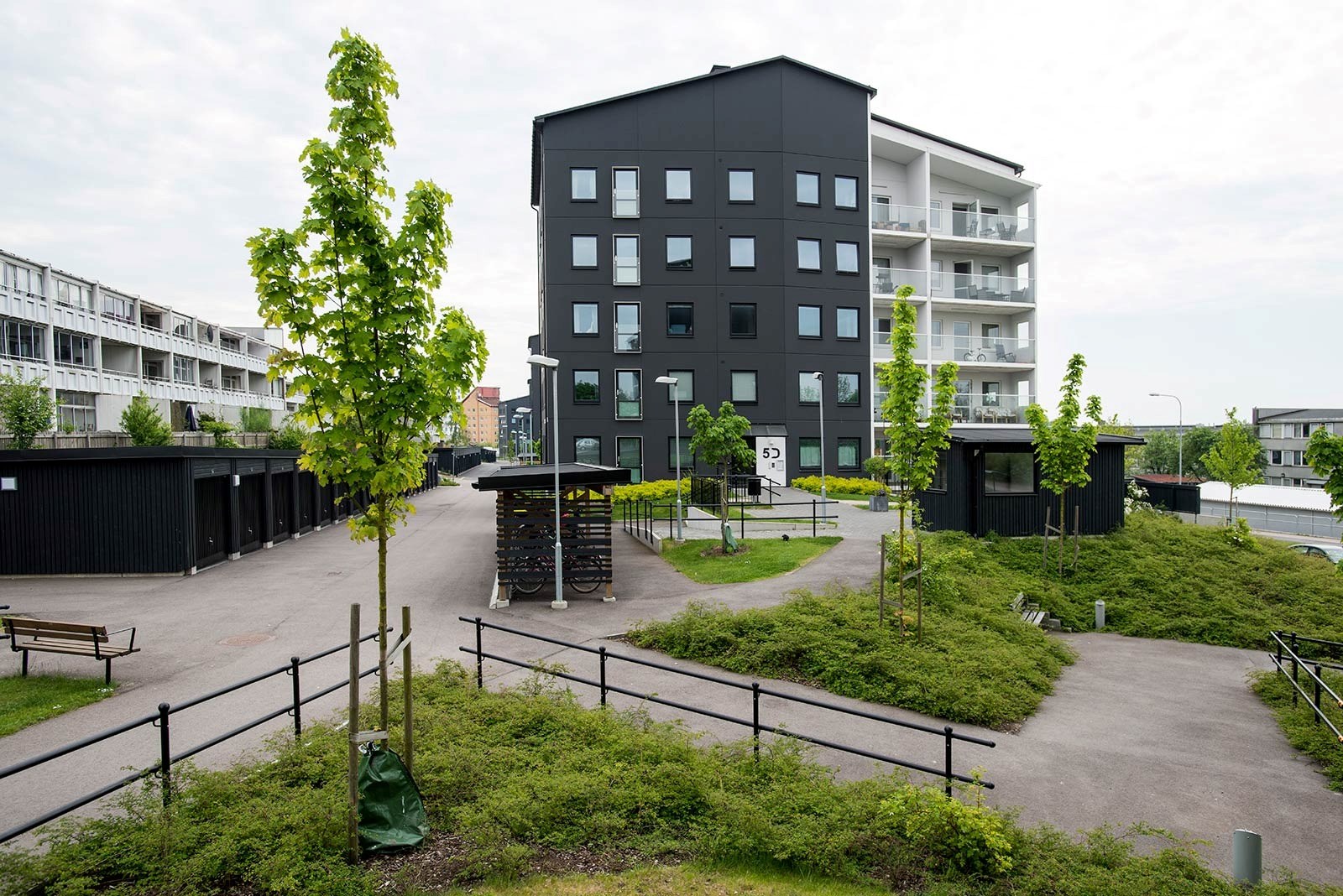 Fastigheter bakom en grönskande yta