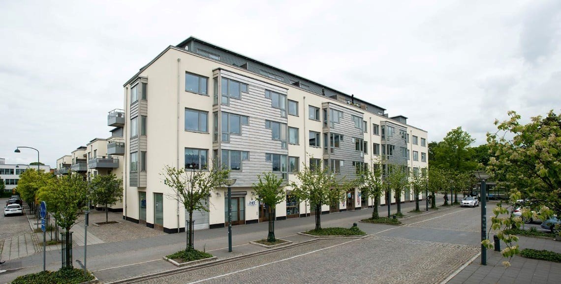 En fastighet med gröna träd framför