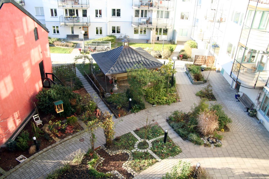 Innergård med vackra planteringar och stenläggningar i Russinet kollektivhus
