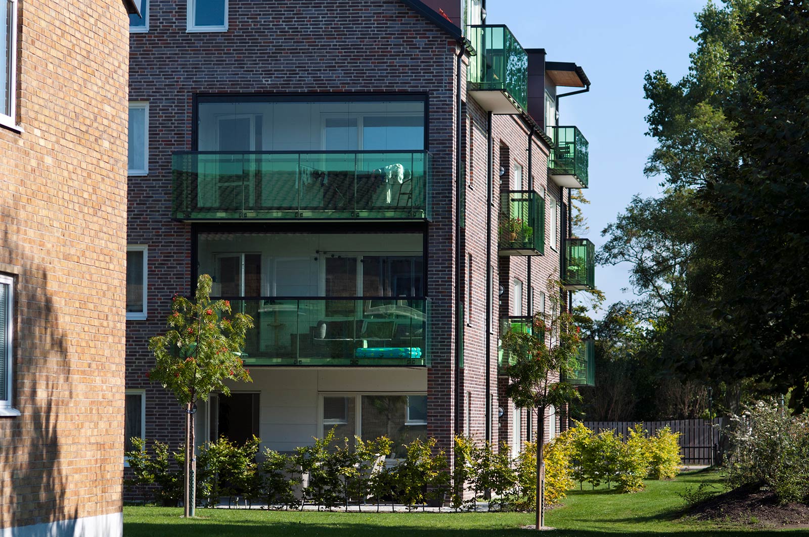 Det nya flerfamiljshuset i Vapenhuset med balkongräcken i grönt glas