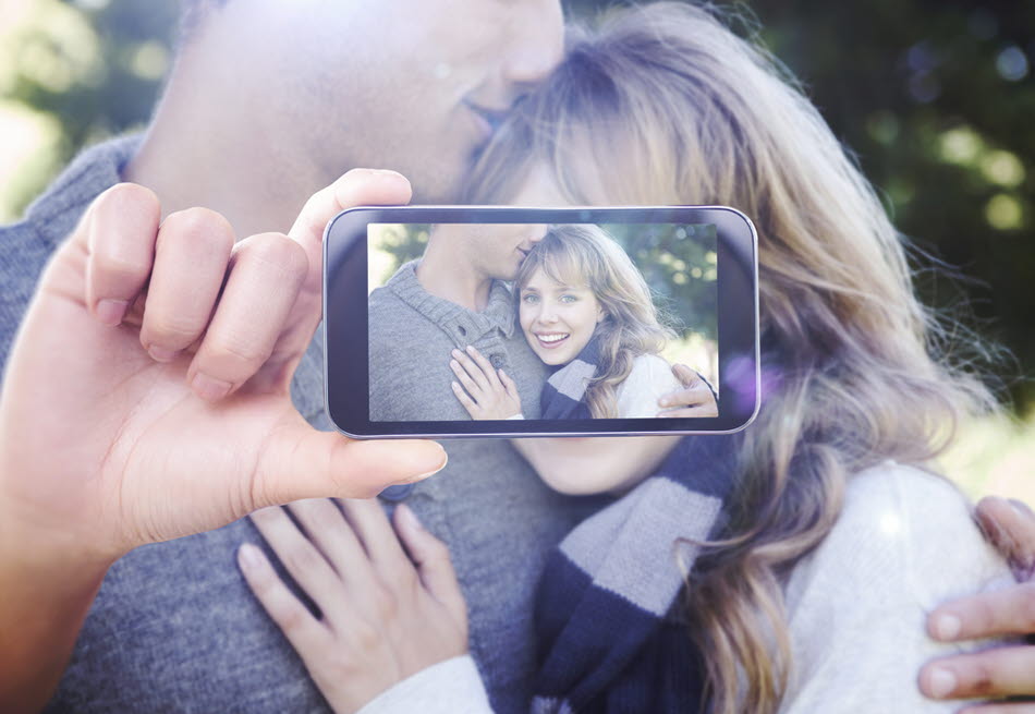 En mobil som tar en bild på ett leende par
