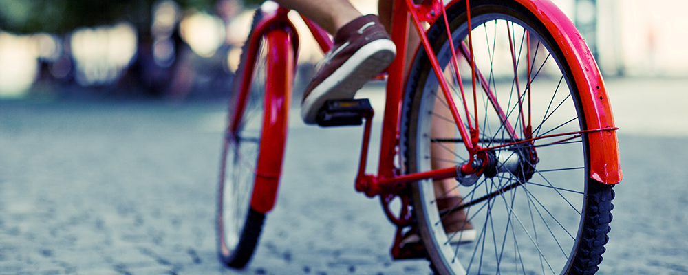 Röd cykel med fot på pedalen